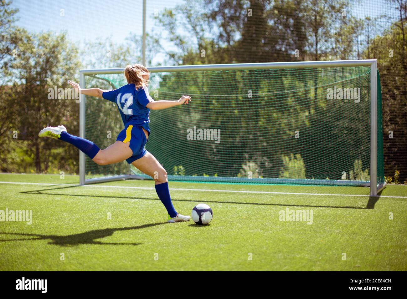 Side View Of Unrecognizable Female Athlete Shooting Ball Into Goal While Playing Football On Field Stock Photo Alamy