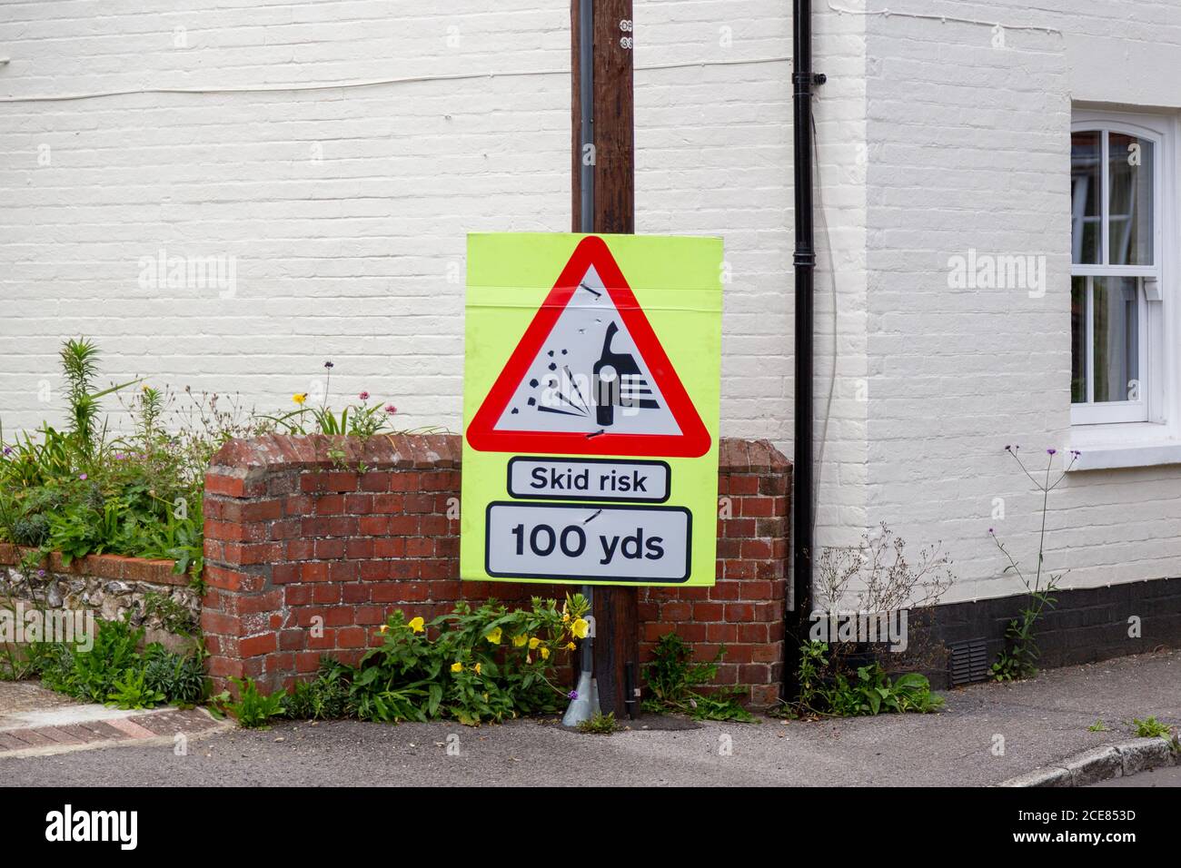 A skid risk sign on the side of the road Stock Photo