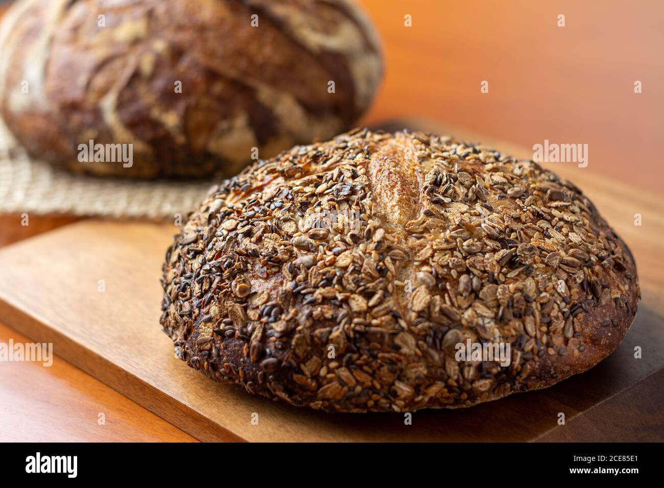 An artisan bread loaf with seeds on wooden background Stock Photo