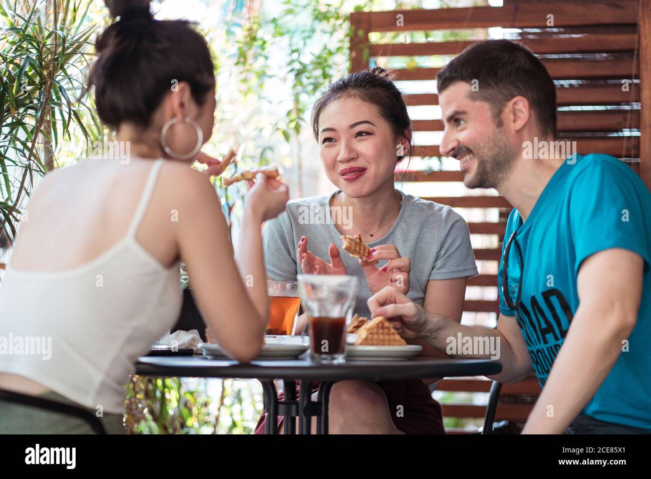 Cheerful multiethnic friends having lunch in cafe Stock Photo