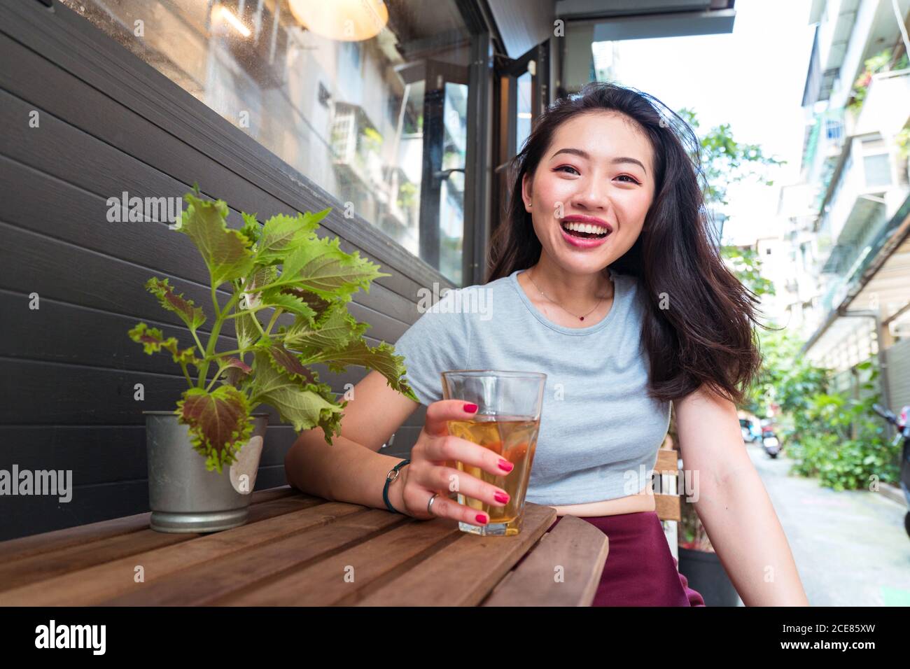 Young Asian female sitting at counter with fresh drink in cafe and ...