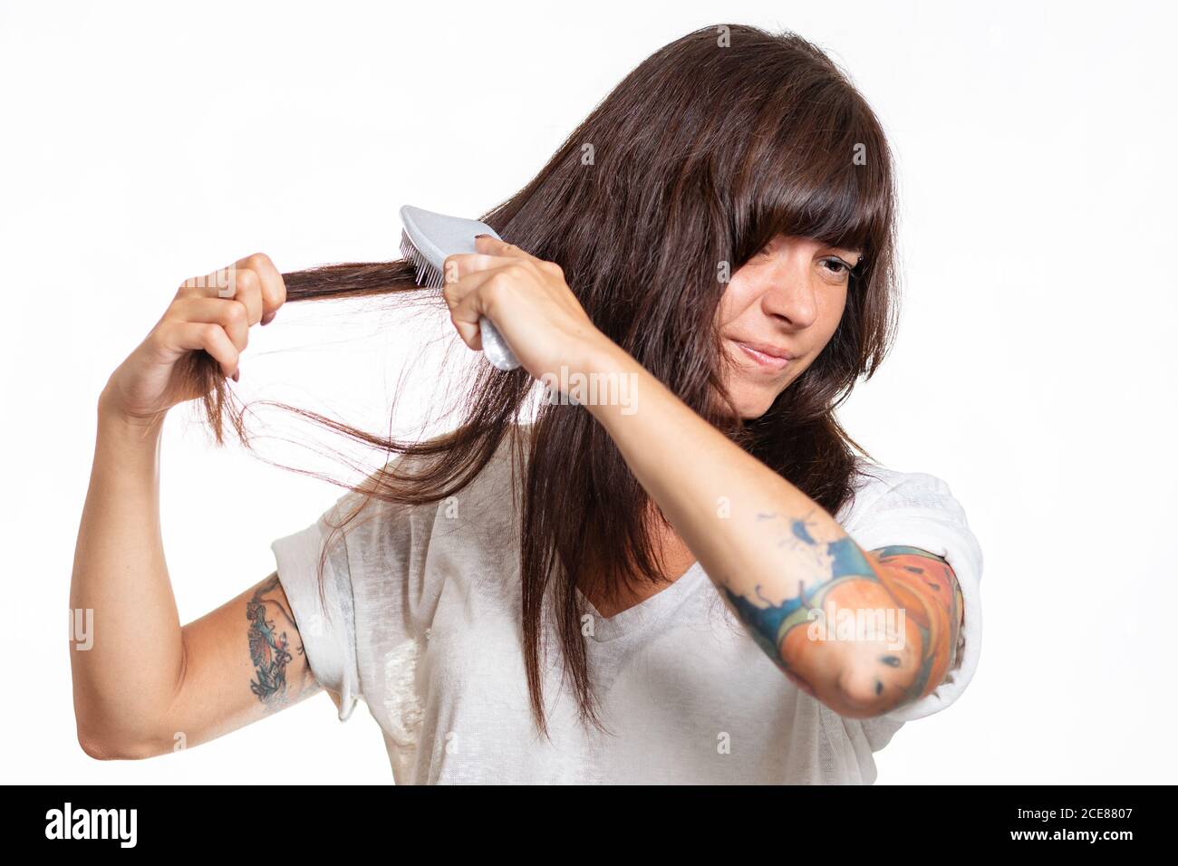 Portrait of a woman with tattoos combs a lock of hair, experiencing pain and pulling out her hair. White background. The concept of hair loss and care Stock Photo - Alamy Portrait of a woman with tattoos combs a lock of hair, experiencing pain and pulling out her hair. White background. The concept of hair loss and care Stock Photo - Alamy