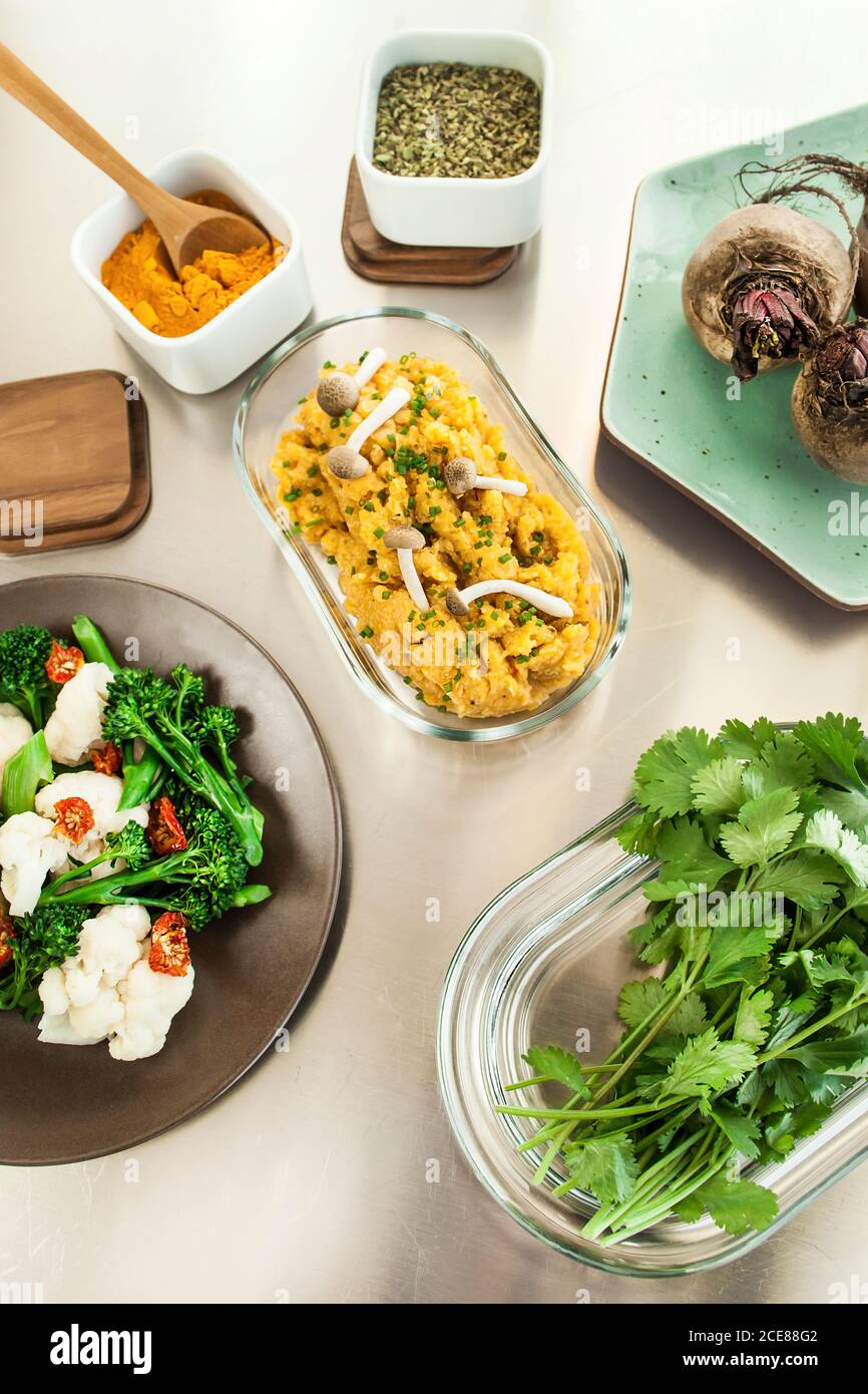 From above of bowl of pumpkin puree with mushrooms and salad of broccoli and cheese Stock Photo