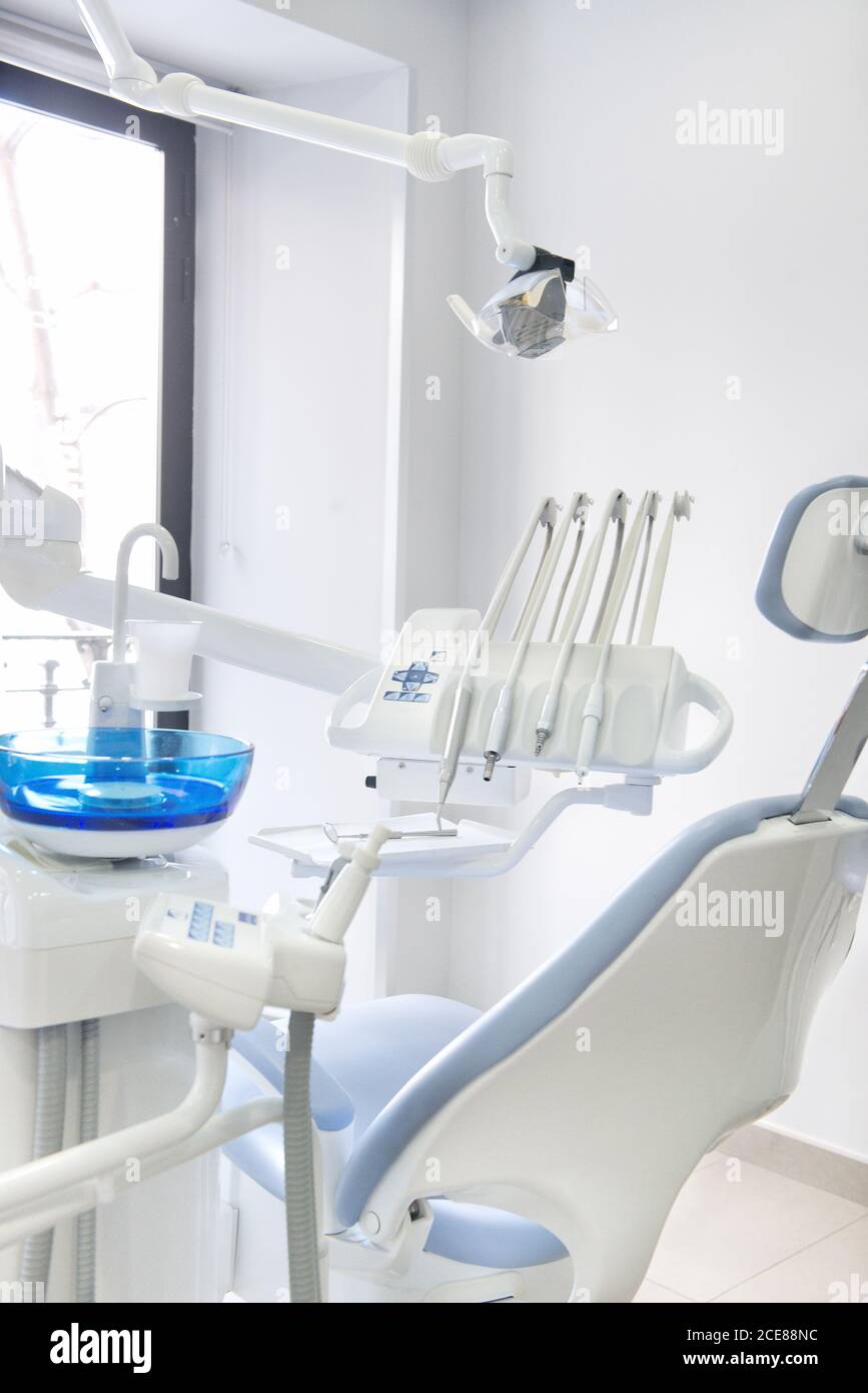 Leather dental chair with various medical instruments located in white dentist office Stock Photo