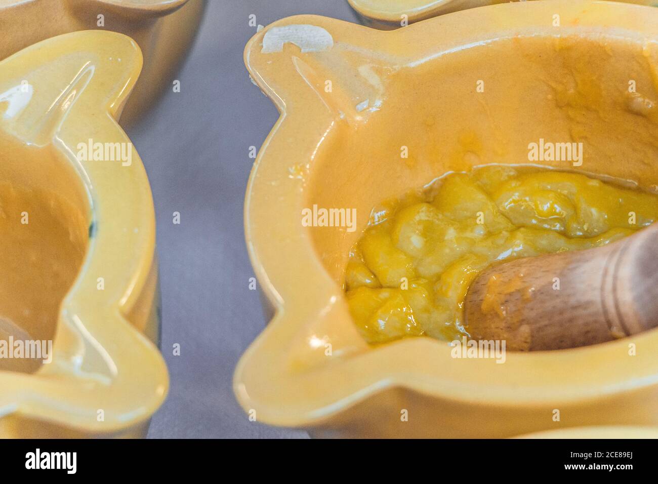 Alioli sauce being prepared in small yellow bowls Stock Photo