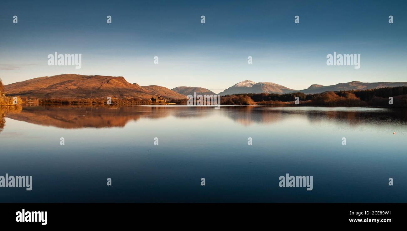 Winter sun shines on Kilchurn Castle, Glen Orchy and Glen Lochy valleys, and Ben Lui mountain beside Loch Awe lake in the West Highlands of Scotland. Stock Photo