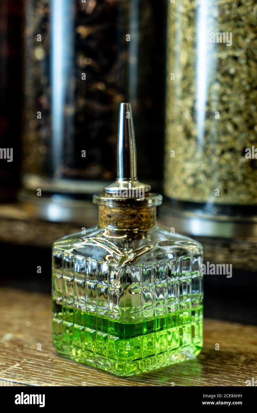 Glass bottle of green absinthe with dispenser placed on counter in retro pub Stock Photo