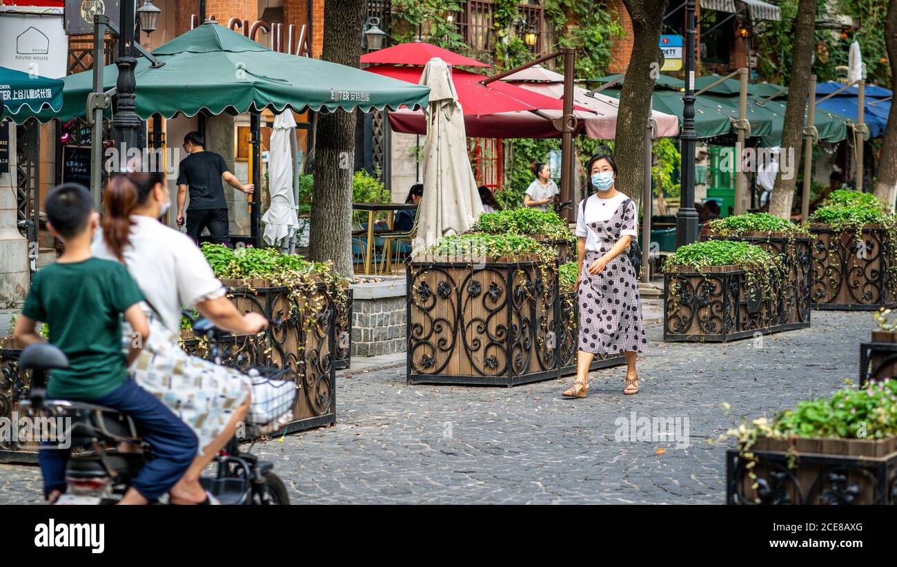 Wuhan China , 30 August 2020 : Woman wearing surgical face mask in pedestrian street of former Hankou concession district in Wuhan Hubei China Stock Photo