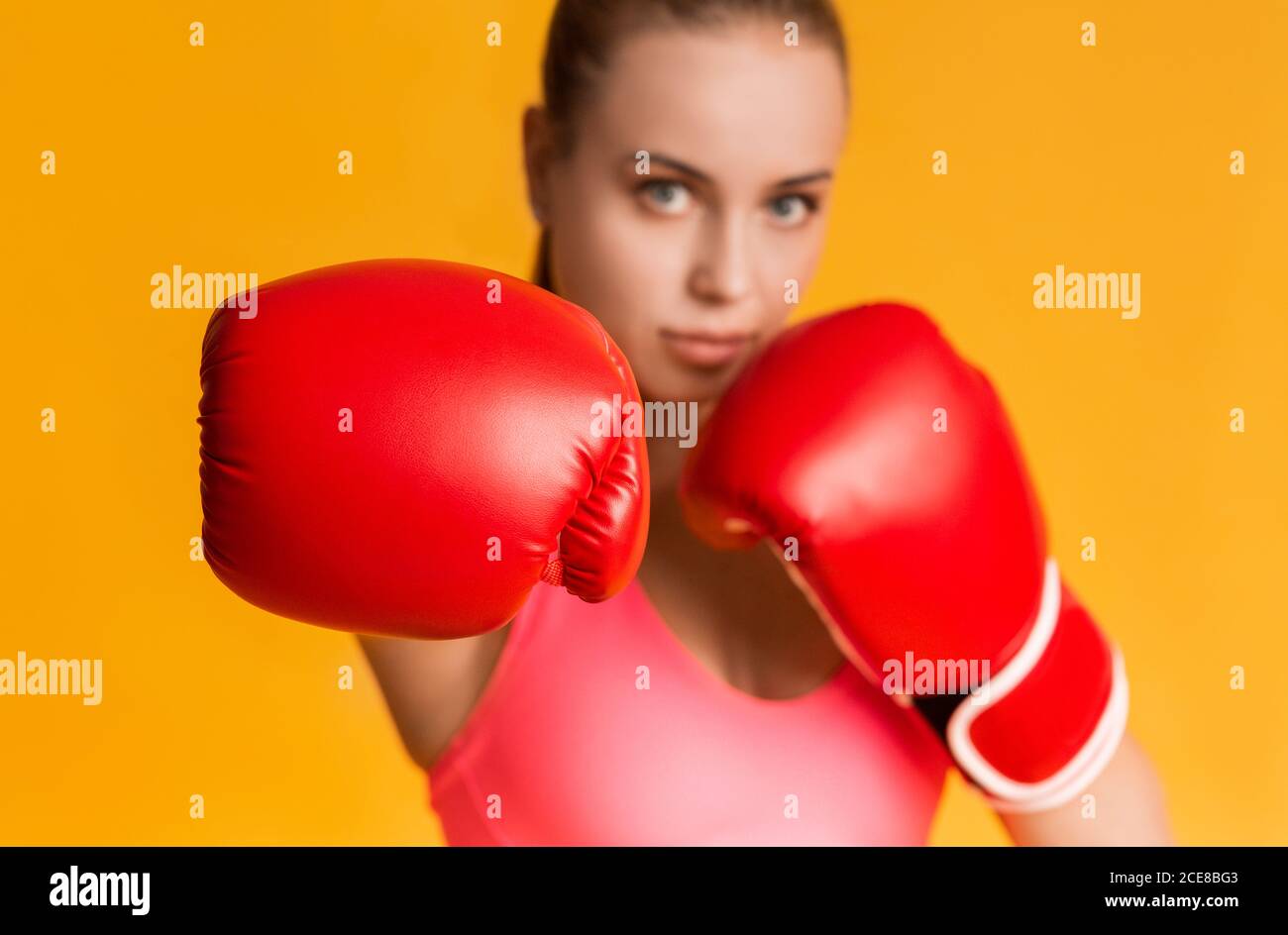 Young Sporty Girl Wearing Red Boxing Gloves, Making Hook Gesture Stock