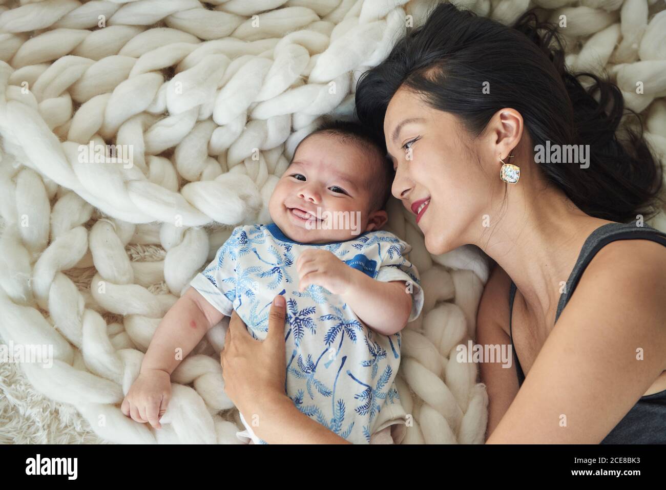 Mother lying with her son in bed Stock Photo