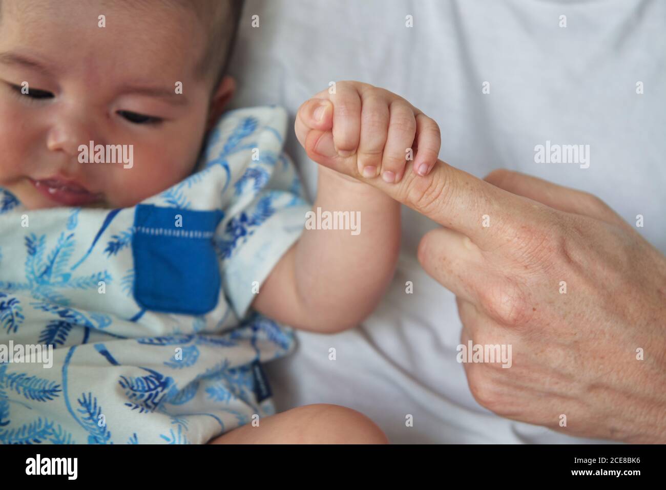 Baby holding his father's hand Stock Photo