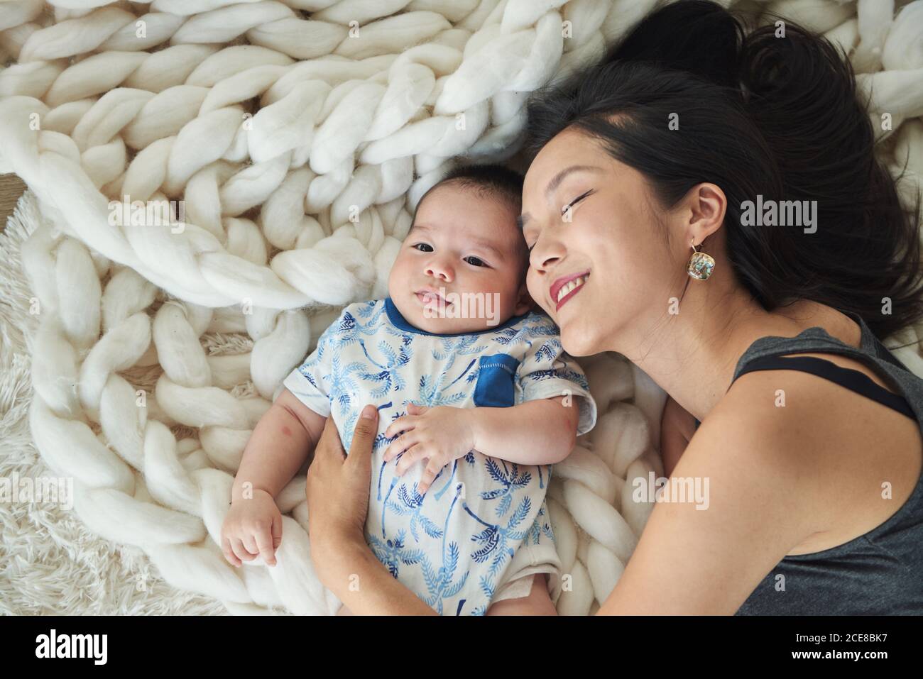 Mother lying with her son in bed Stock Photo