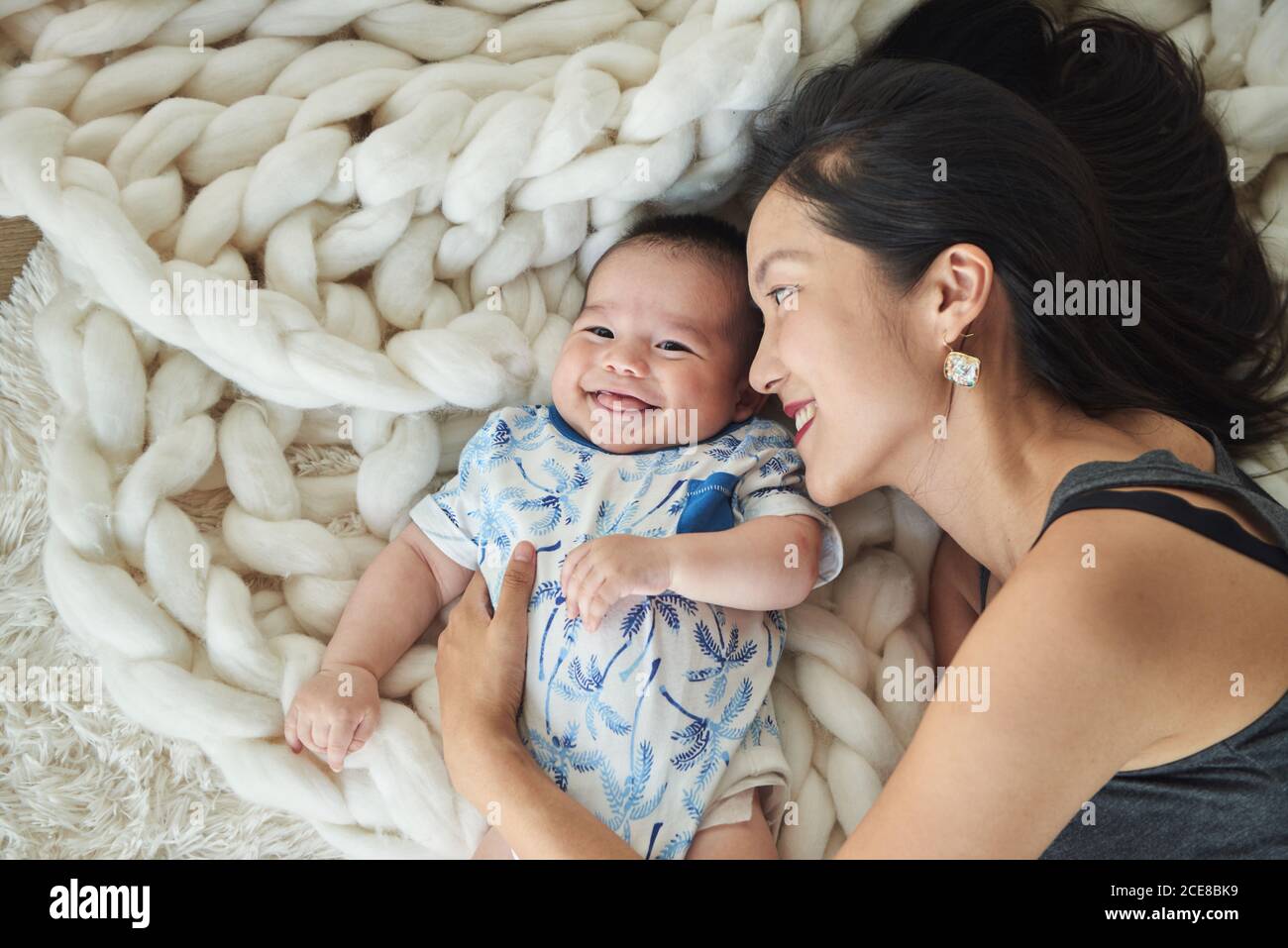 Mother lying with her son in bed Stock Photo