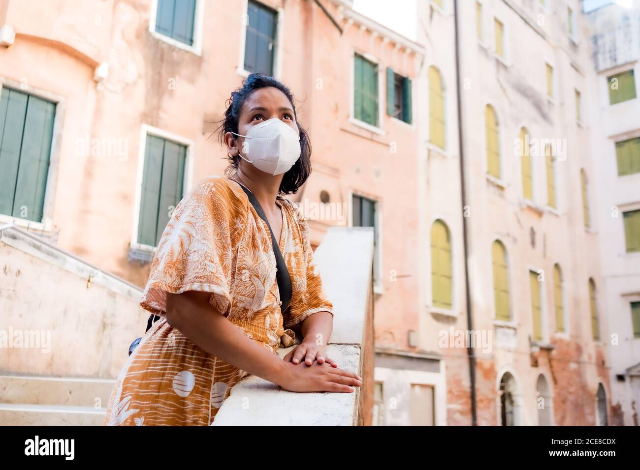 young tourist wearing face mask going around in a street of Venice in Italy. traveling and tourism industry during the corona virus pandemic and covid Stock Photo