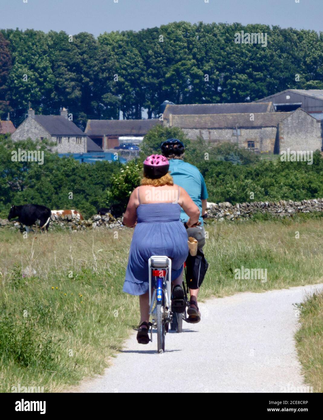 Caucasian Couple Cycling On Their Bicycles The Tissington Trail, Peak District National Park, Derbyshire, England, UK In June Stock Photo