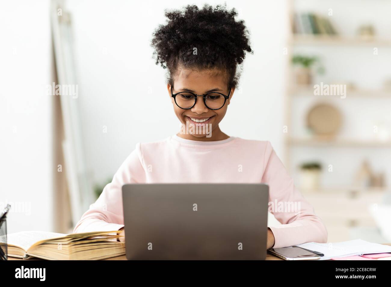 Happy African Teen Girl Studying At Laptop Computer At Home Stock Photo