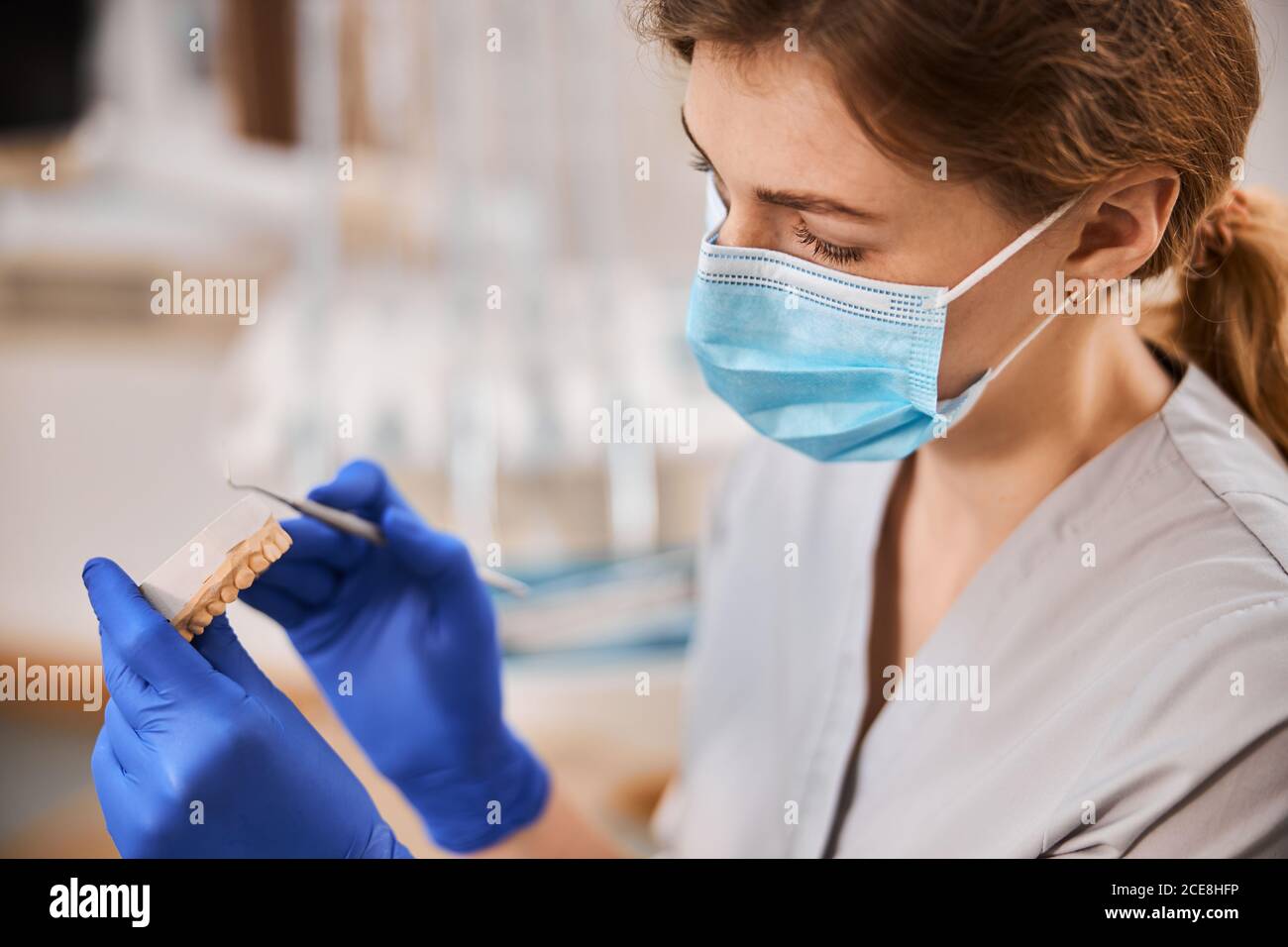 Dental technician inspecting a plaster cast mold of teeth Stock Photo