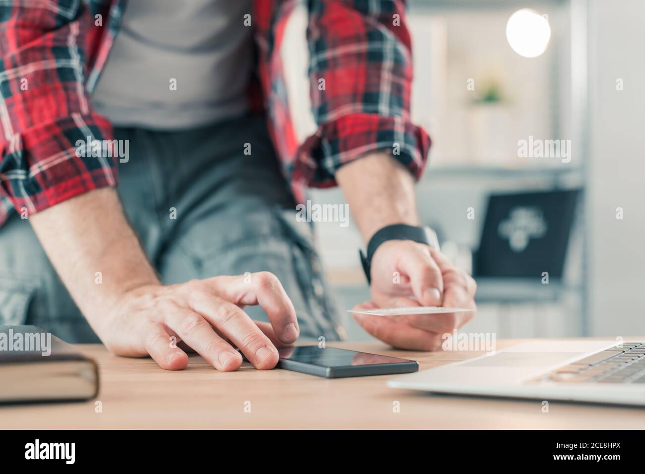 Freelancer shopping online with smartphone app and credit card from small business home office, selective focus Stock Photo