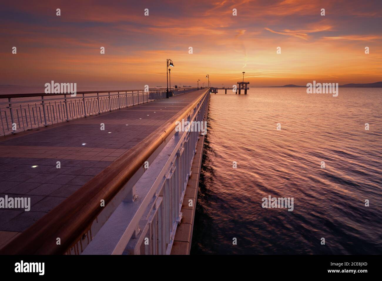 Dramatic sunrise on the beach in Burgas, Bulgaria. Sunrise on the Burgas Bridge. Bridge in Burgas - symbol of the city. Stock Photo