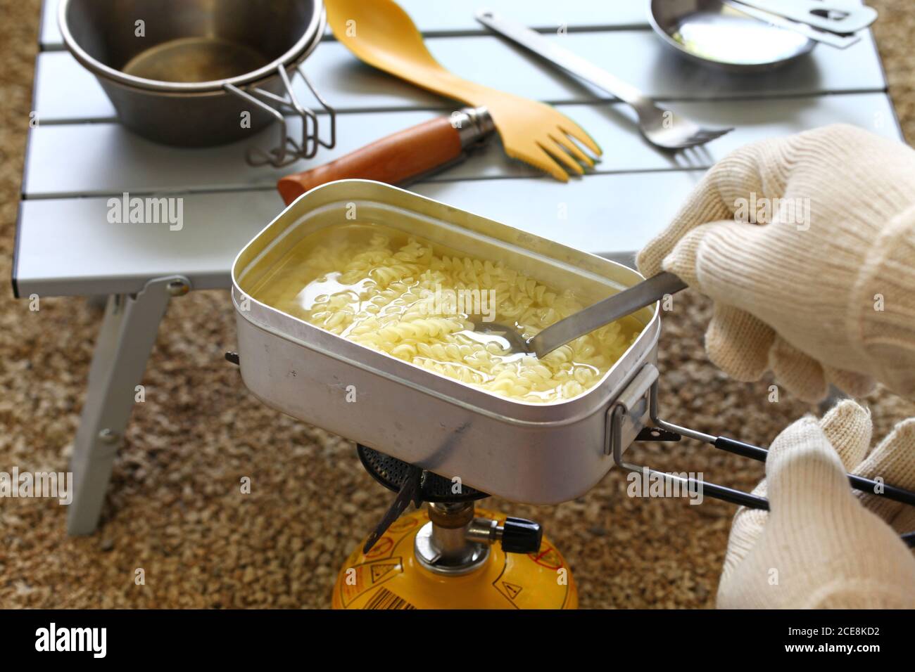 camping cooking. boiling pasta in mess tin Stock Photo Alamy