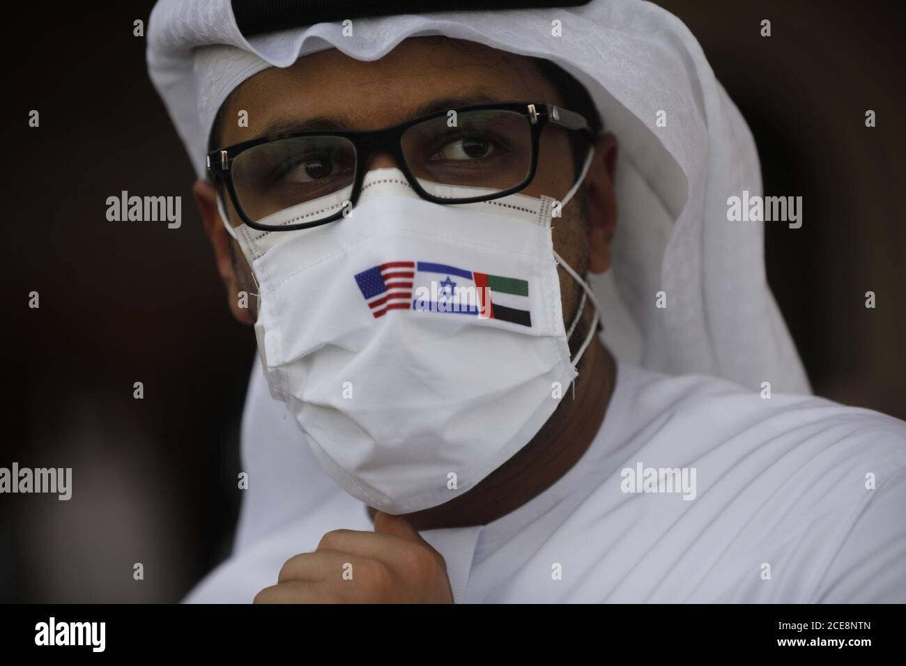 Lod, Israel. 31st Aug, 2020. A man wearing a mask bearing the national flags of America, Israel and United Arab Emirates, looks on after an Israeli flag carrier El Al airliner carrying Israeli and American delegates landed in Abu Dhabi, United Arab Emirates on Monday, August 31, 2020. Talks are scheduled to put final touches on the normalization deal between the United Arab Emirates and Israel. Pool Photo by Nir Elias/UPI Credit: UPI/Alamy Live News Stock Photo