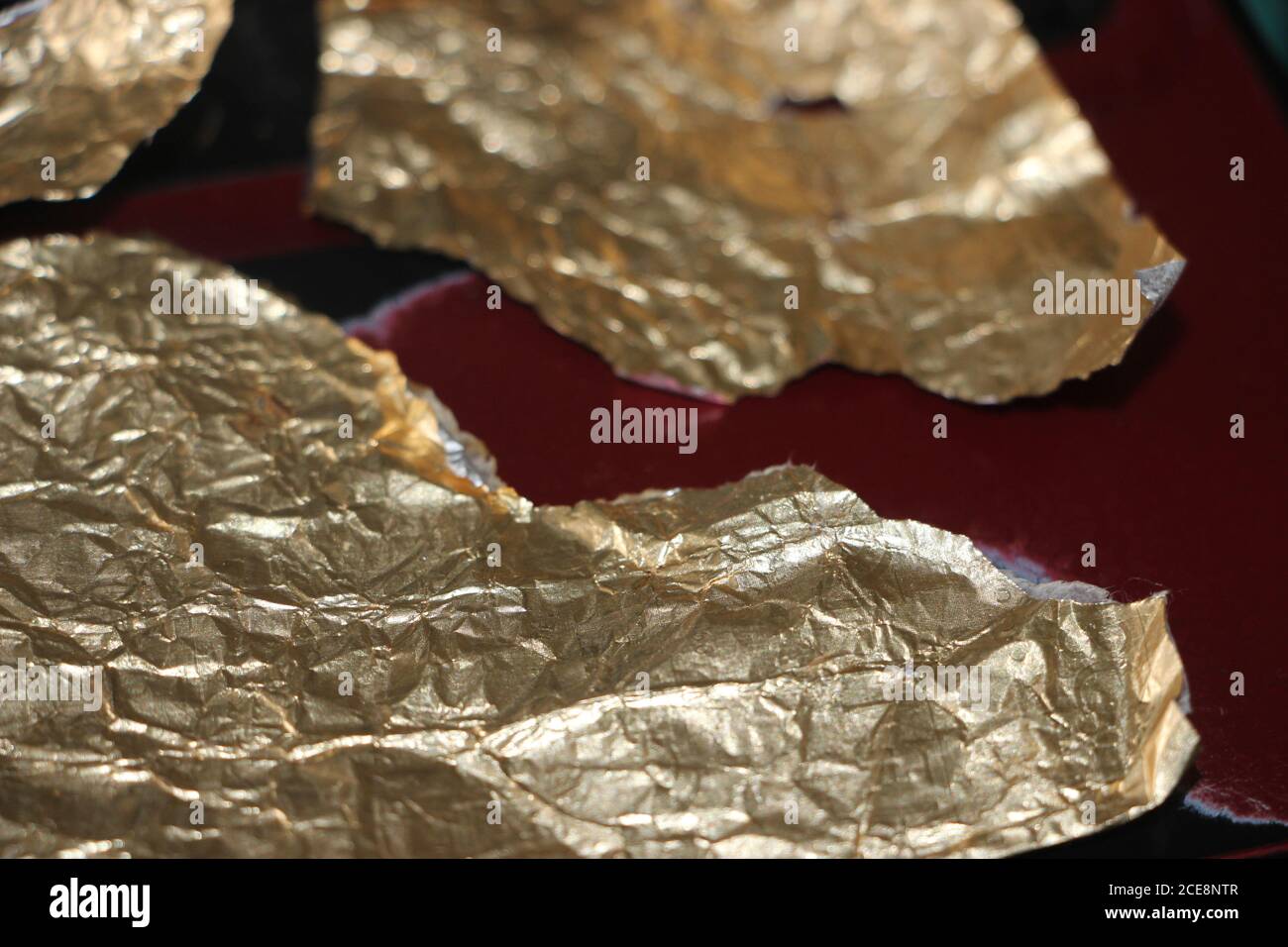 Crumpled and torn golden bronze shiny foil texture background Stock Photo