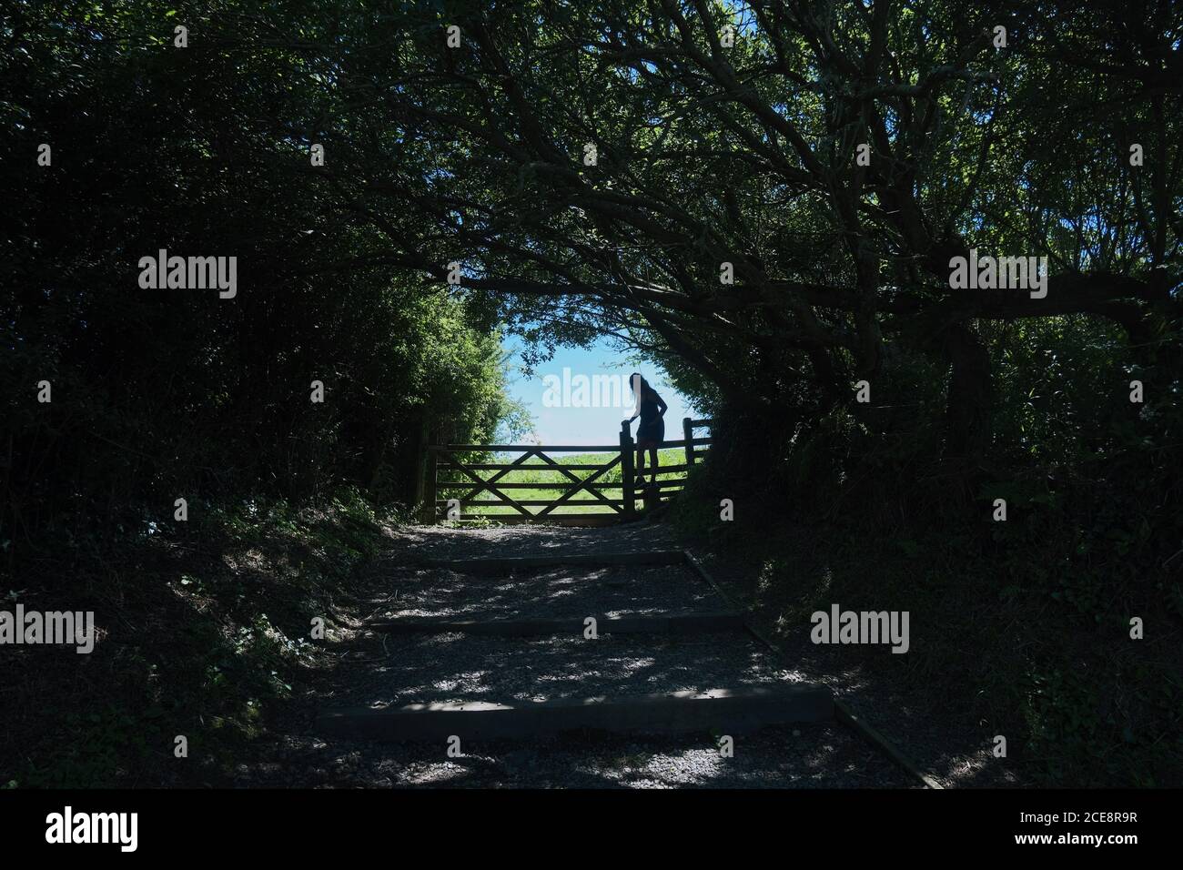 Girl crossing stile on a countryside walk Stock Photo