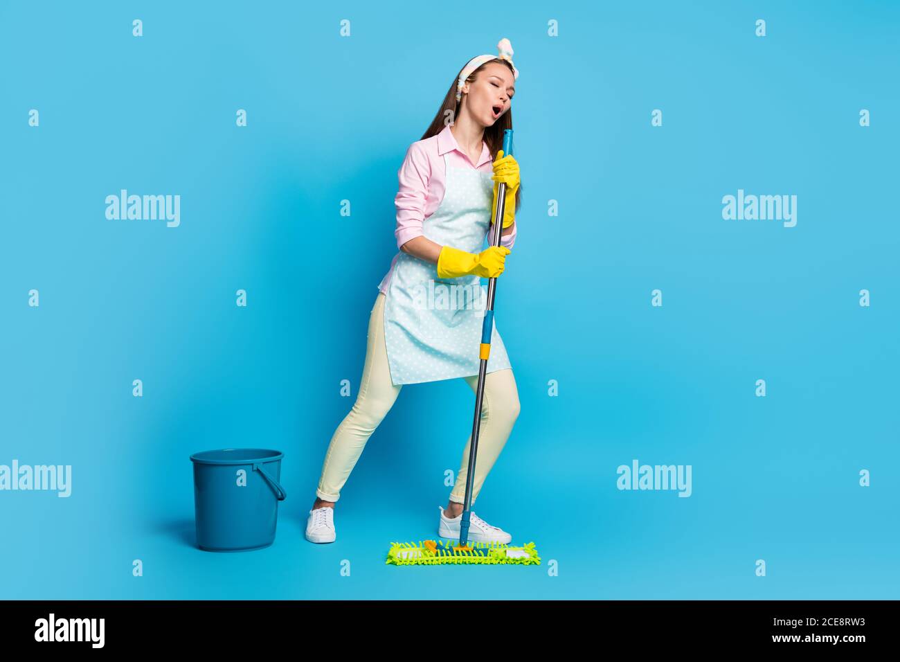 Full length photo of positive hipster wife wash floor mop imagine she pop  star sing song wear style stylish trendy pink shirt pants trousers yellow  Stock Photo - Alamy