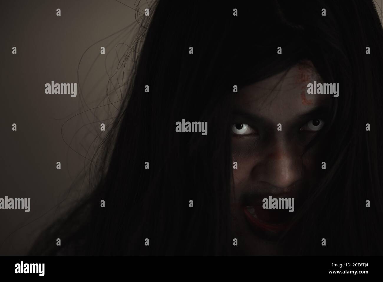 Girl zombie in blood. Closeup face and eyes of Asian Woman ghost with