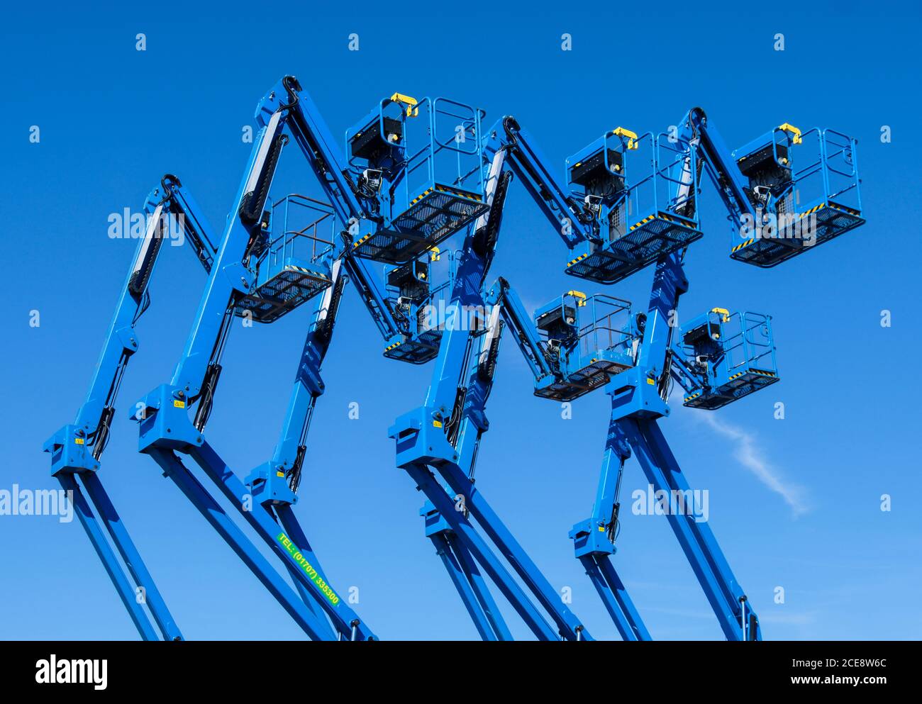 A yard full of articulating boom lifts  or cherry pickers. Stock Photo