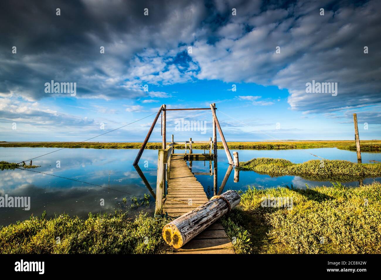 A jetty points to the distant salt marsh. Stock Photo