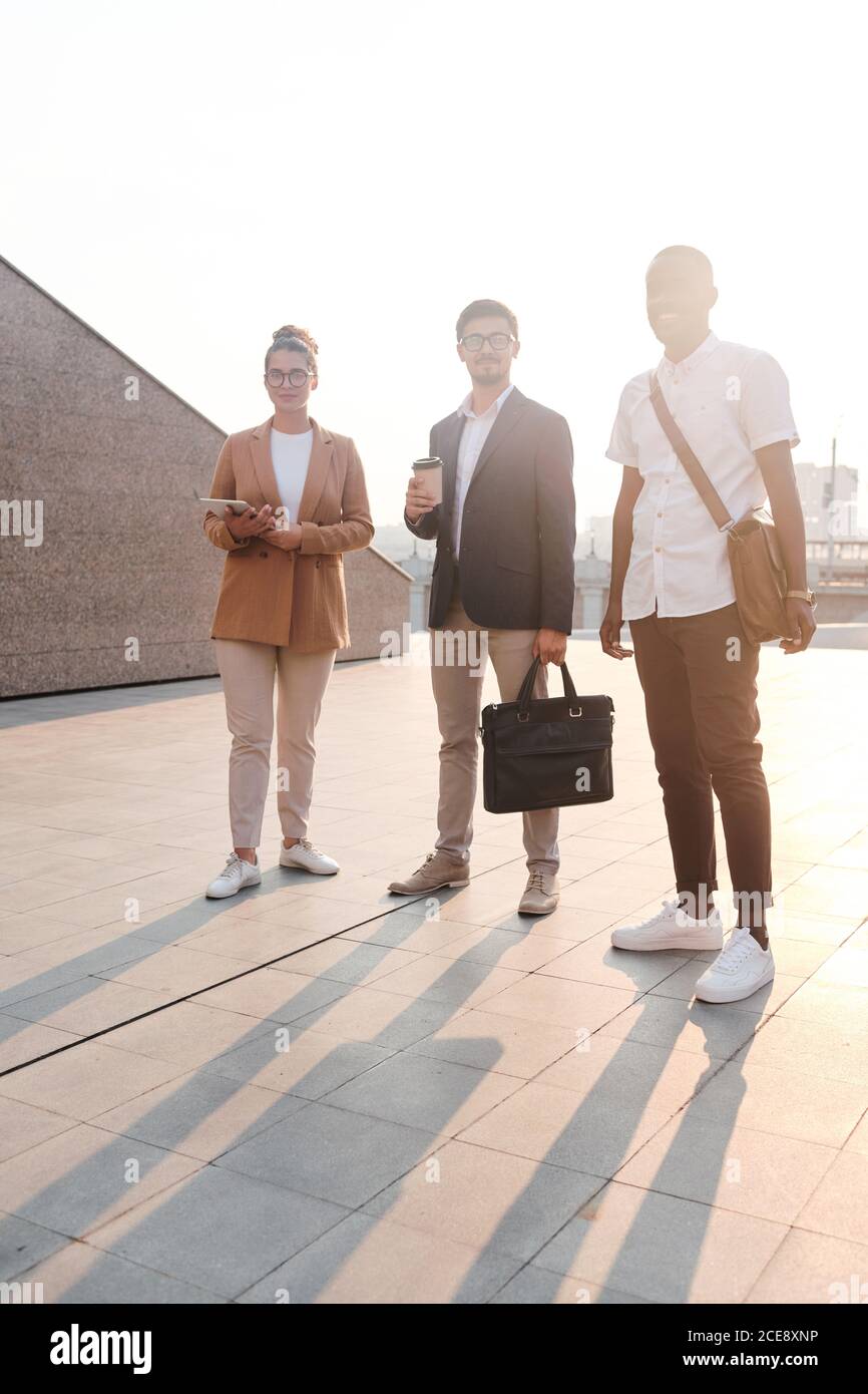 Portrait of content confident young multi-ethnic business professionals standing in sunlight outdoors Stock Photo