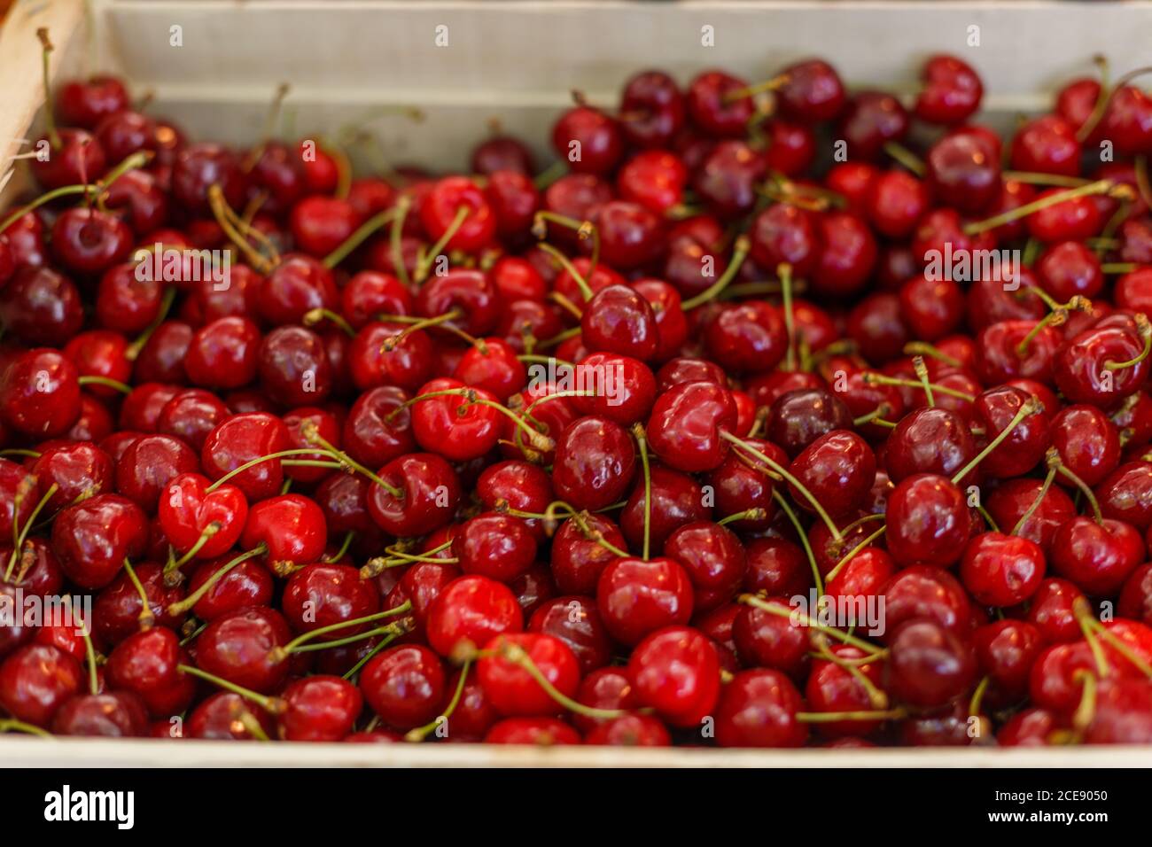 Pile of delicious cheery placed in wooden container on counter in local