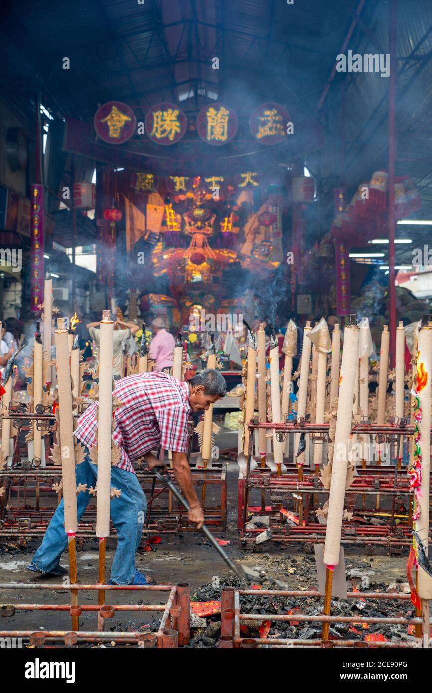 Bukit Mertajam, Penang/Malaysia - Aug 13 2016: A man clear the dust of dragon joss stick at floor during hungry ghost festival. Stock Photo