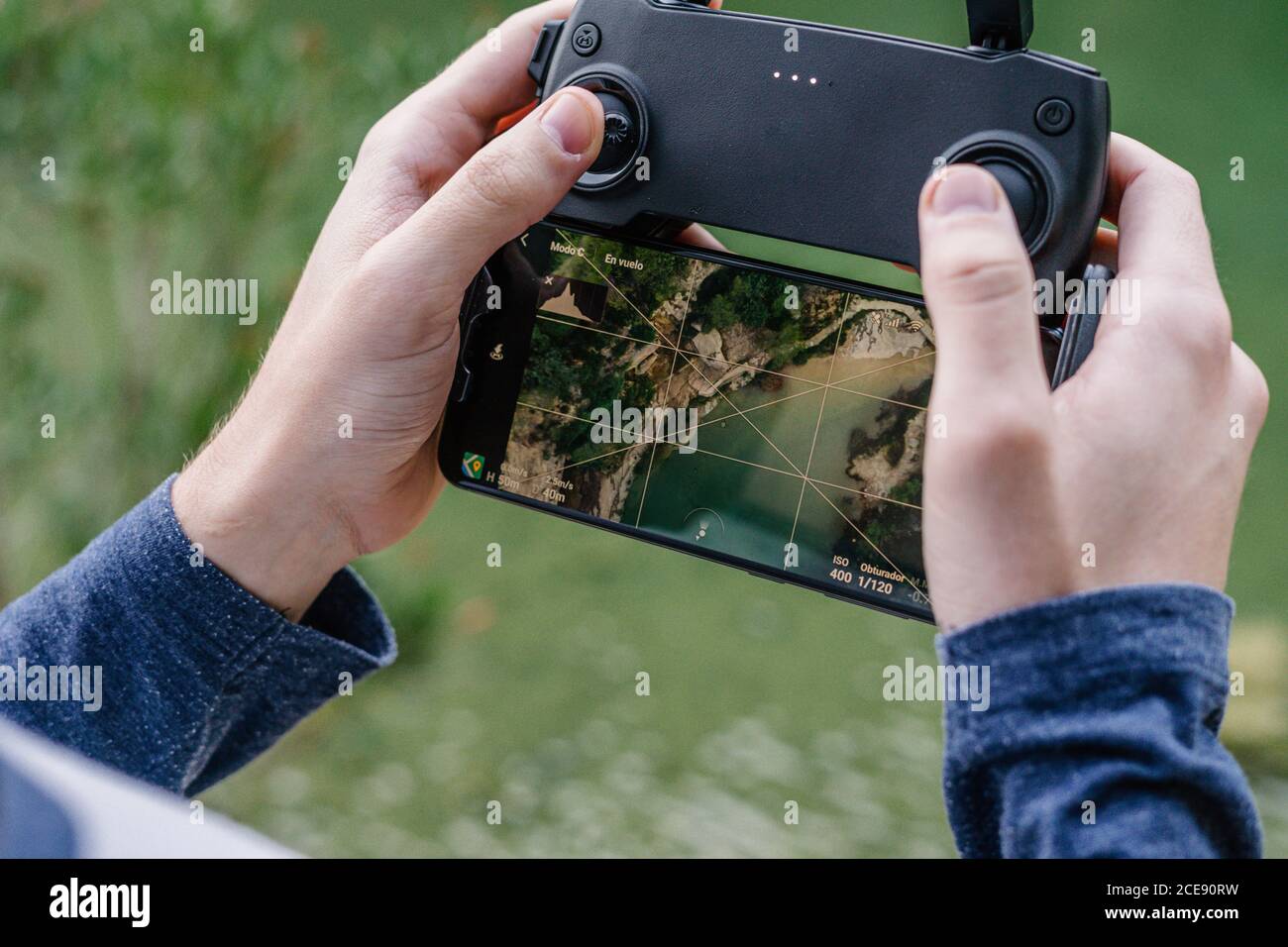 unrecognizable male with remote controller operating unmanned drone and recording video of spectacular landscape Stock Photo