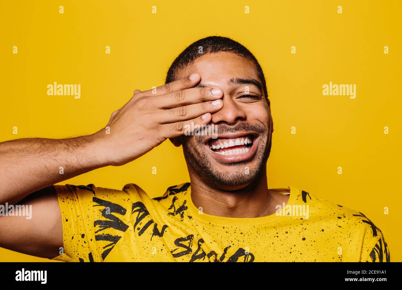 Portrait of cheerful man smiling and looking at camera over plain yellow background Stock Photo