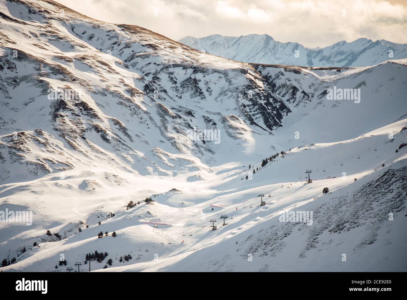 Severe Cold Winter Landscape With Snowy Rocky Mountain Peaks And Sunlight Breaking Through Stock Photo Alamy