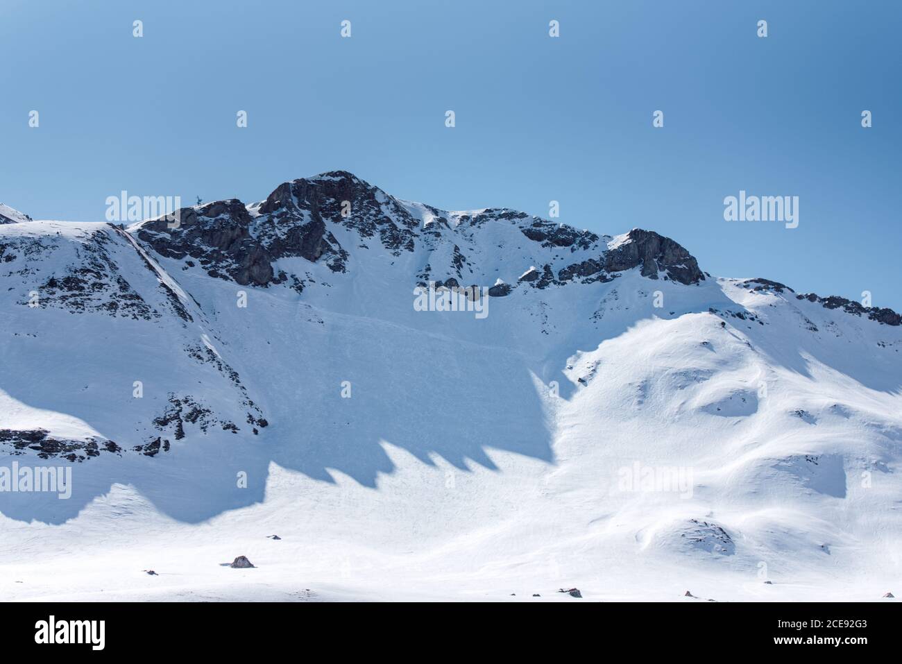 Severe Cold Winter Landscape With Snowy Rocky Mountain Peaks And Sunlight Breaking Through Stock Photo Alamy