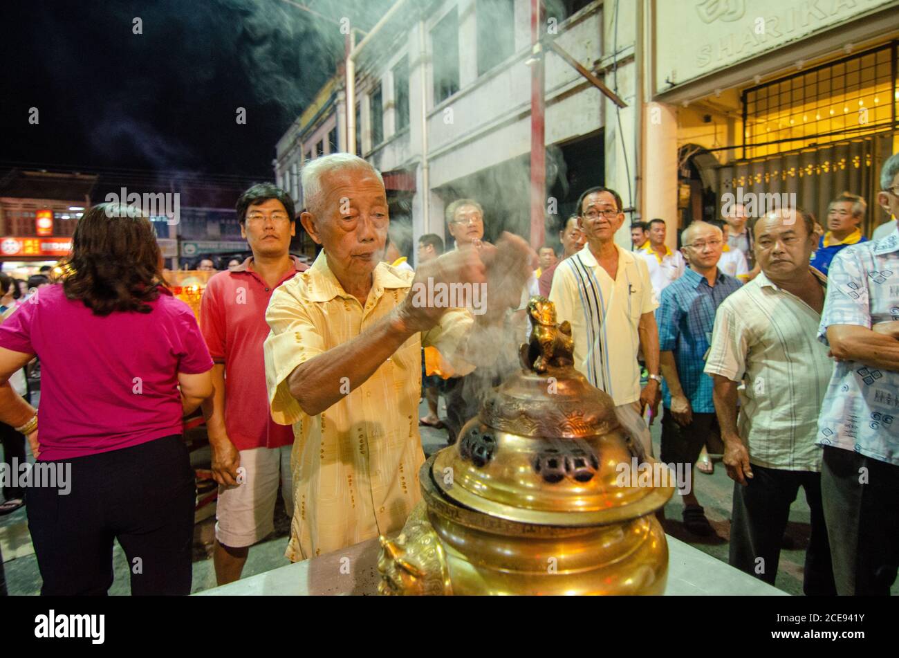 Bukit Mertajam, Penang/Malaysia - Aug 19 2016: Old man seek for blessing from the smoke release from pot. Stock Photo