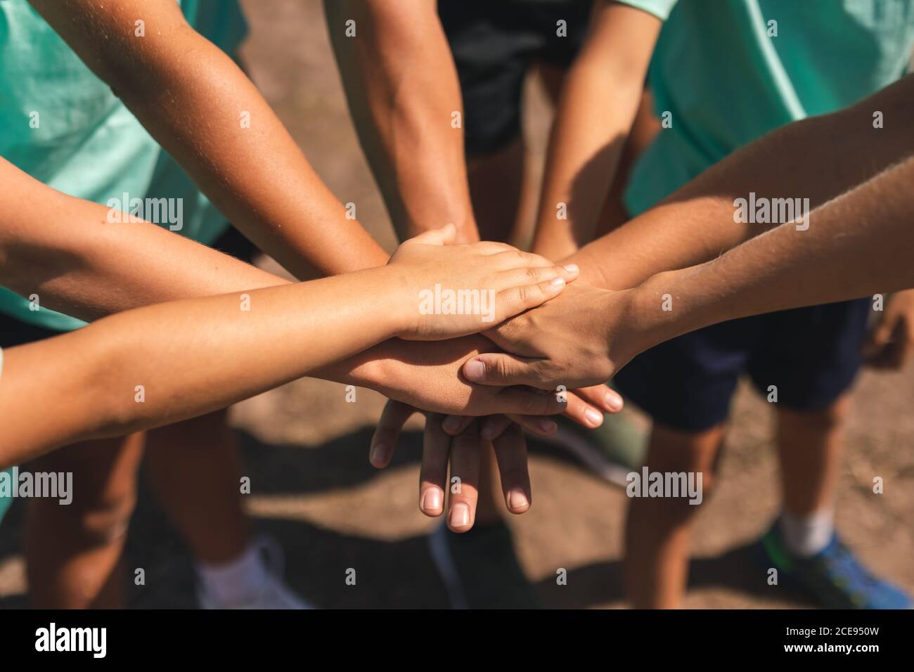 Mid section of group of kids stacking hands together Stock Photo