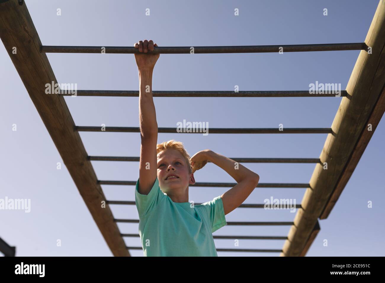 Boy hanging on monkey bars at a boot camp Stock Photo