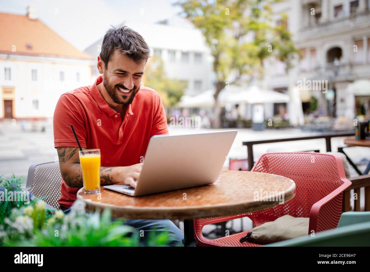 Handsome young man with laptop enjoying his free time in cafe Stock Photo