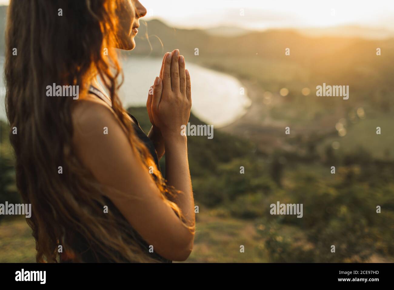 Woman praying alone at sunrise. Nature background. Spiritual and emotional concept. Sensitivity to nature Stock Photo