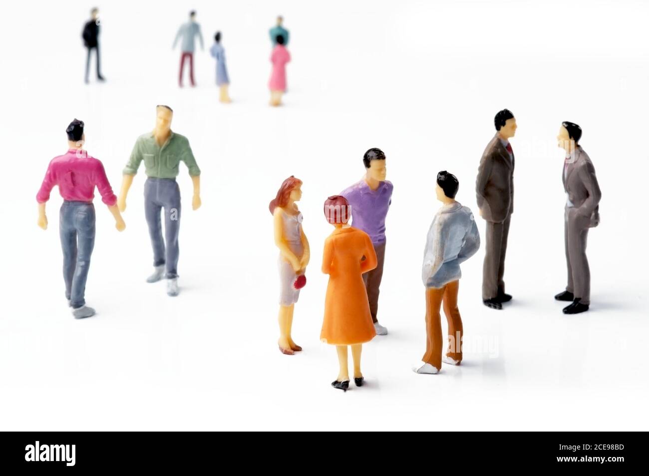 A Group of Figurine People on a White Backdrop Stock Photo