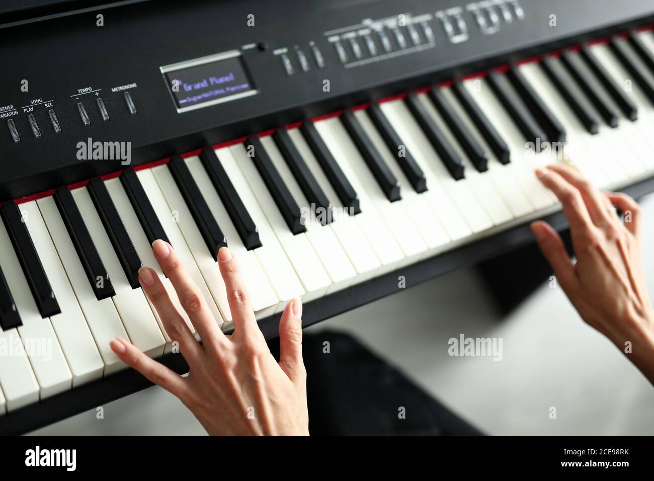 Beautiful female hands lie on a digital piano Stock Photo