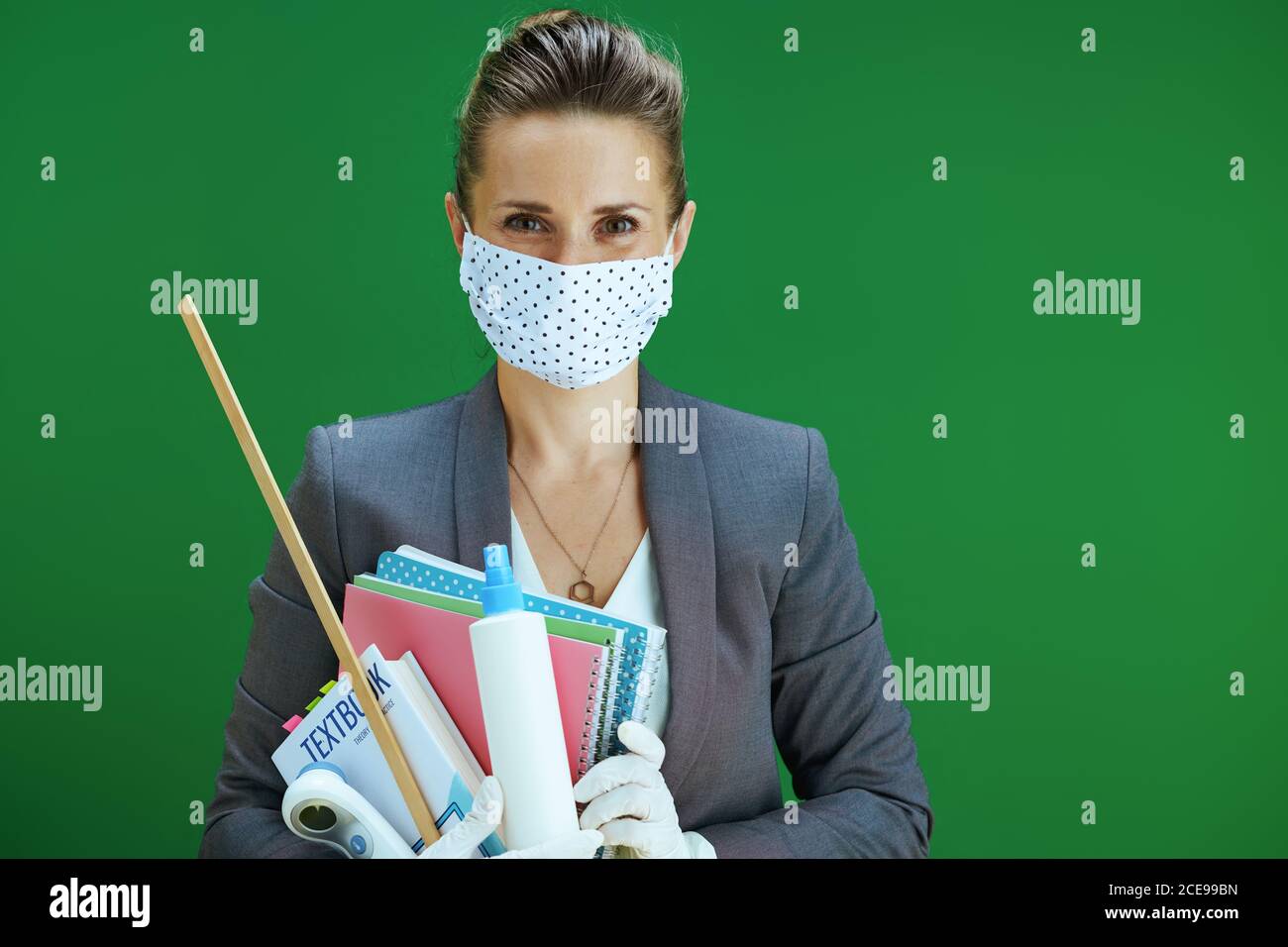 Portrait of modern female teacher in white blouse with medical mask ...