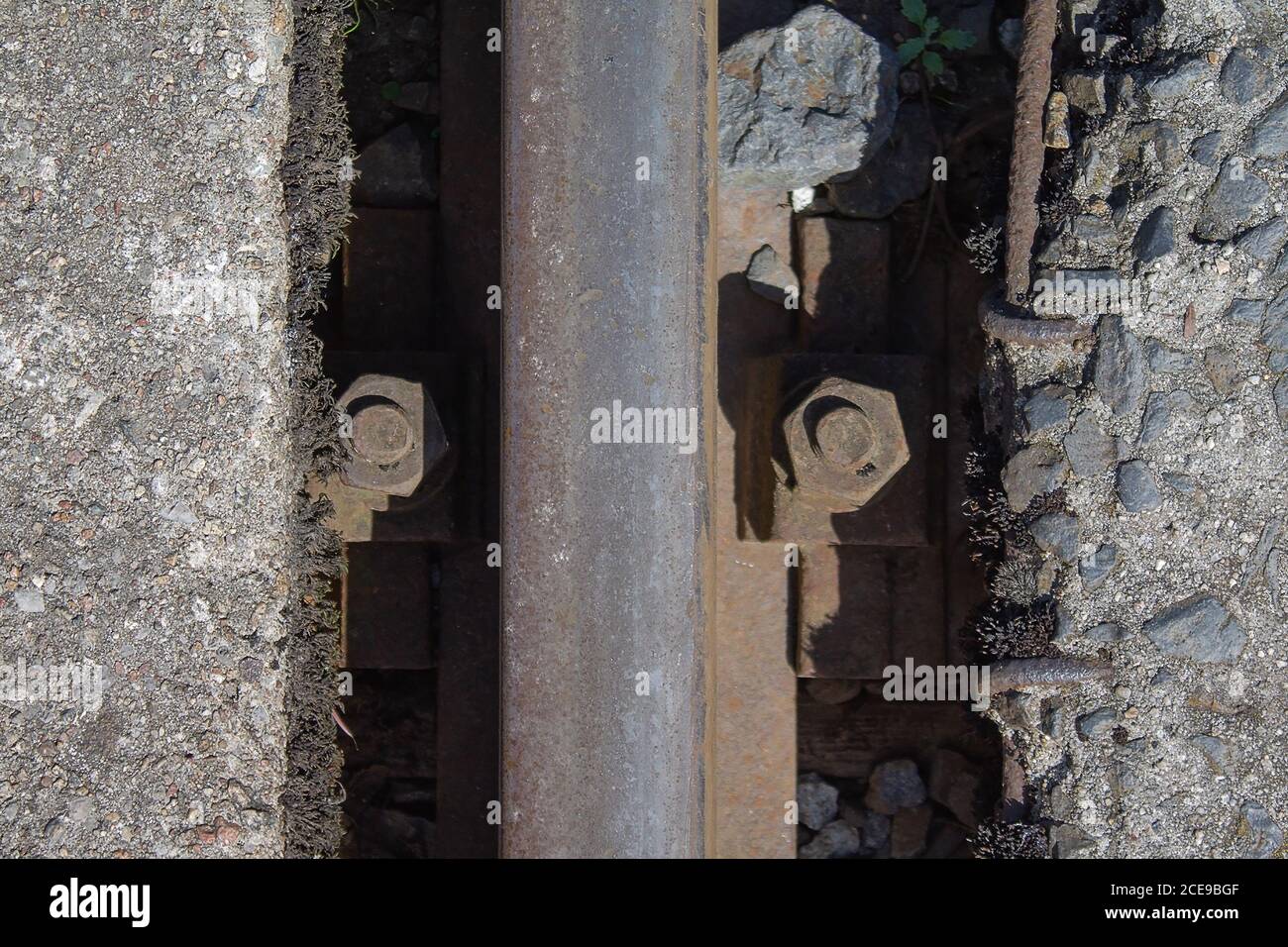 Rail track fastening screws in the track bed. As you can see it was mounted a long time ago. Stock Photo