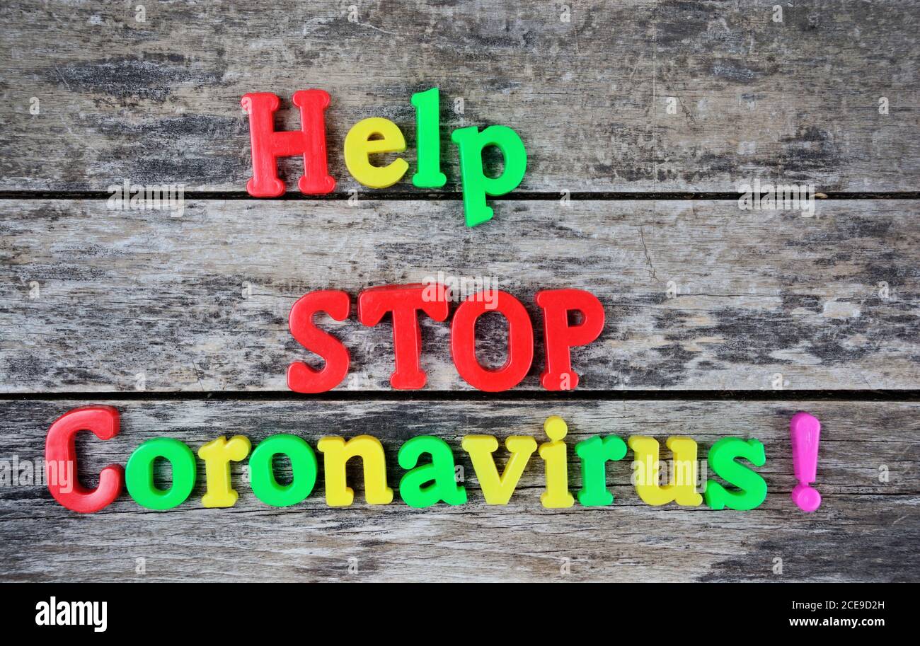 Help Stop Coronavirus words on an old wooden table Stock Photo