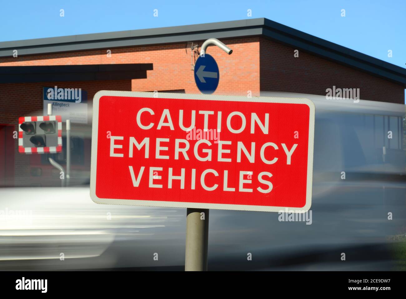 caution emergency vehicles warning sign and lights outside fire station leeds united kingdom Stock Photo