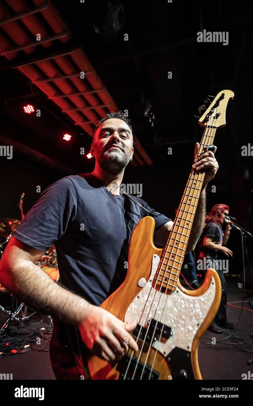 Caucasian Man is Performing on the Stage with Band. Handsome Male Person is Playing on Bass Guitar at Concert. Stock Photo